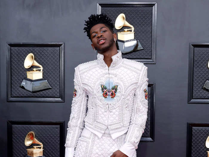 Lil Nas X arrived in a custom Balmain suit dripping in pearls.