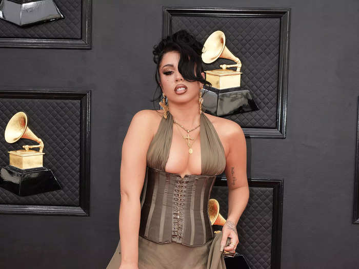 Kali Uchis walked the red carpet in an olive-green dress with a corset top and sheer skirt.