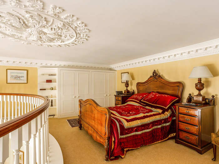 Up on the bedroom mezzanine, you can get a closer look at the delicate cornice work still featured in the home.