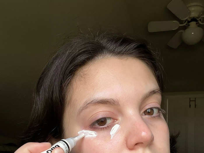 Gabi applied the concealer with its brush tip in strategic spots.