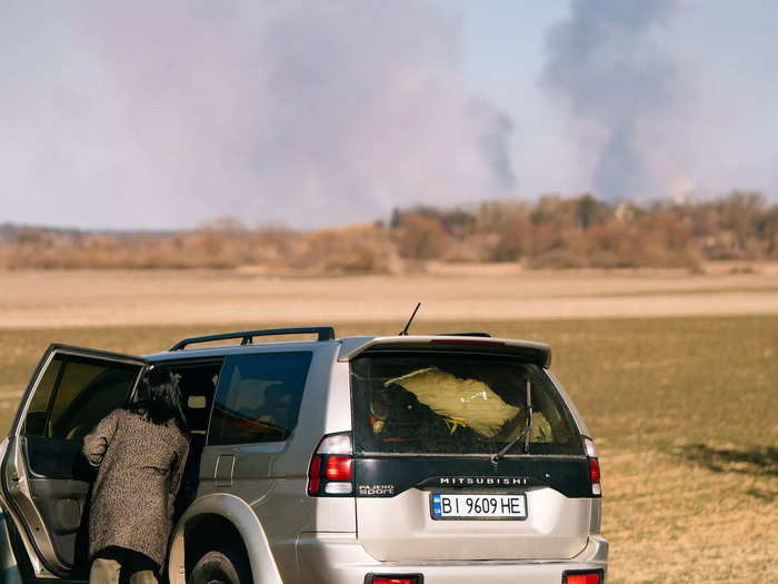 While driving near the Dorohusk border crossing in Poland, I passed by a car stopped on the road. I could see a fire burning in the background across the border in Ukraine.