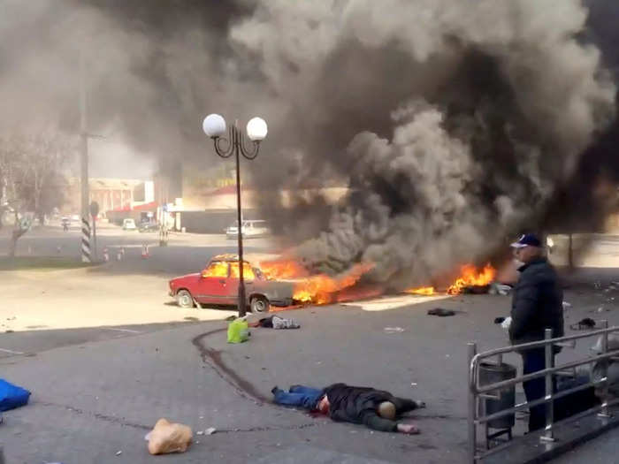 Outside the station burning cars with bodies around it shows the violence of the attack.