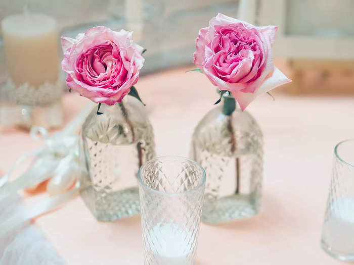 Using small bud vases of flowers to decorate tables is a minimalist wedding trend that