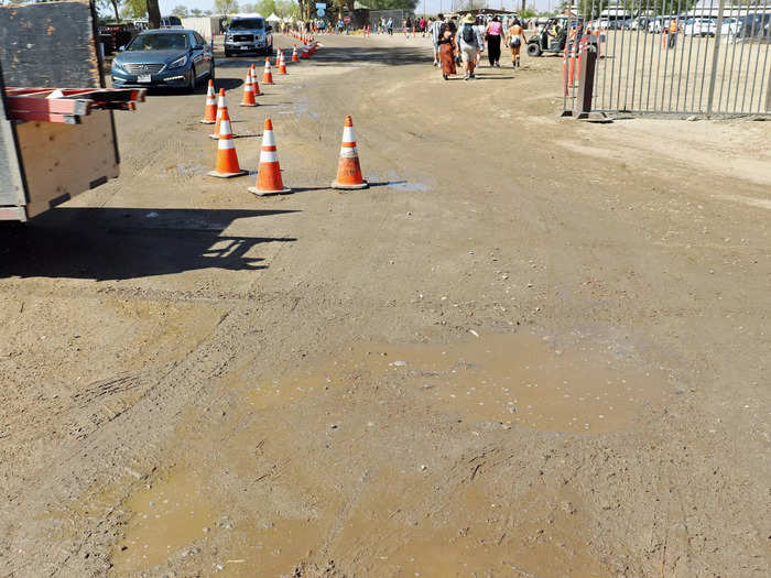 Festival workers try to reduce dust with water, but that often creates mud puddles.