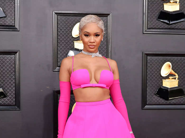 Saweetie slayed the Grammys red carpet in this fuchsia skirt, bra top, and matching gloves.