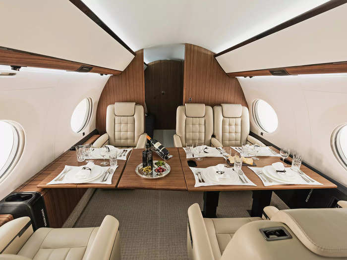 Fold-up tables are stowed at the side of the plane and can be combined to form a dining table.