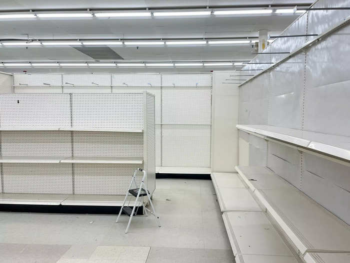 The sea of empty off-white metal shelves glowed under the bright lights.