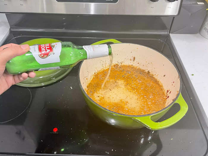 Dump the beer into the simmering vegetables and spices.