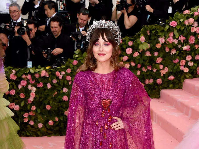 Her most vibrant — and arguably stunning — look was in 2019. Johnson attended that year in a sparkling, fuchsia Gucci gown with sheer long sleeves, a see-through skirt, and a bleeding heart made from sequins in the center of its bodice.