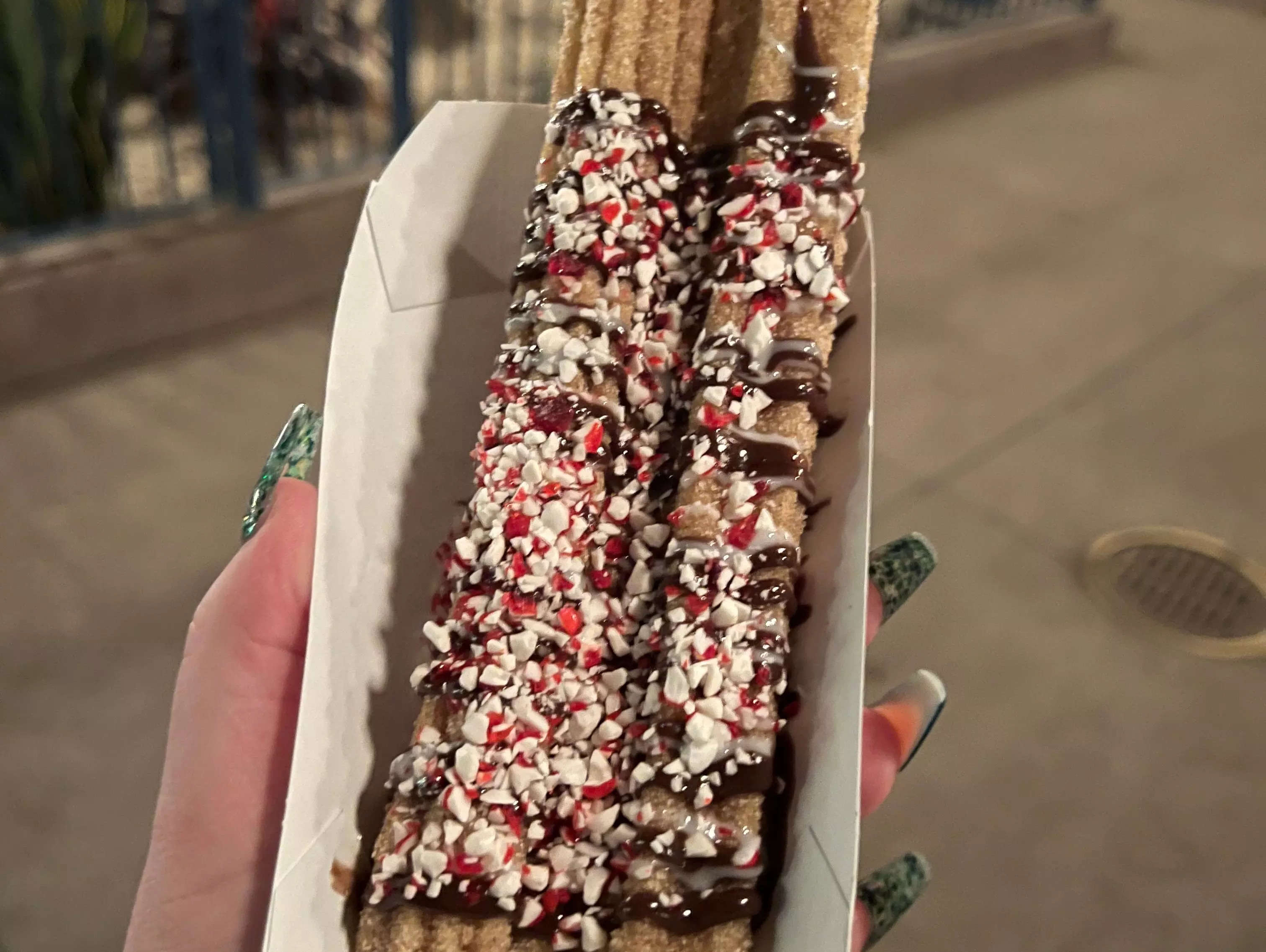 hand holding two peppermint churros from disneyland