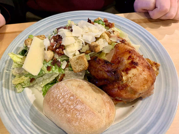 The half chicken dinner came with a breast and leg of a rotisserie chicken, plus a roll and a choice of side — in this case Caesar salad.