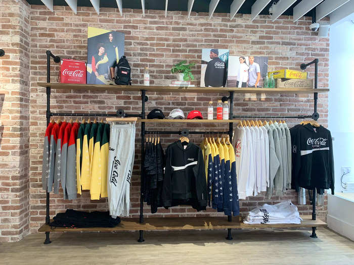 The shop also features a range of other Coca-Cola branded items, including hoodies, sweatpants, and caps.