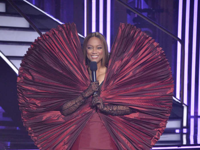 In 2021, Banks wore a maroon dress with a bold fan-like sleeve detail on season 30 of "Dancing with the Stars."