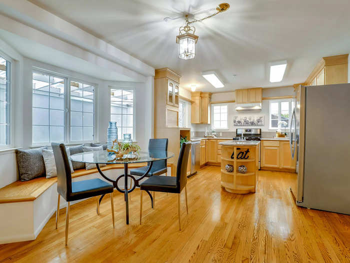 The living room leads into the dining area and open kitchen featuring a center island and breakfast nook.