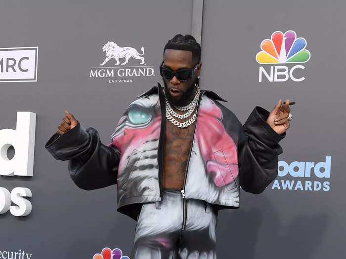 Burna Boy went topless in a coordinating jacket and wide-leg pants with a saber-tooth cat print.