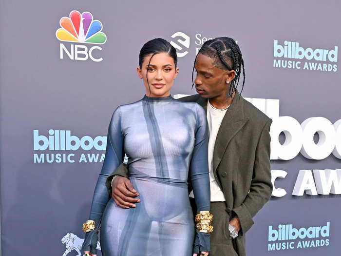 Kylie Jenner wore a sleek two-dimensional grey maxi gown while partner Travis Scott wore a khaki-green suit and a white T-shirt.