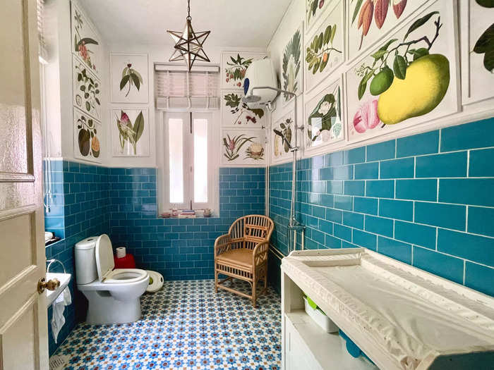 The bathroom on the first floor now has framed botanical prints and turquoise wall tiles.