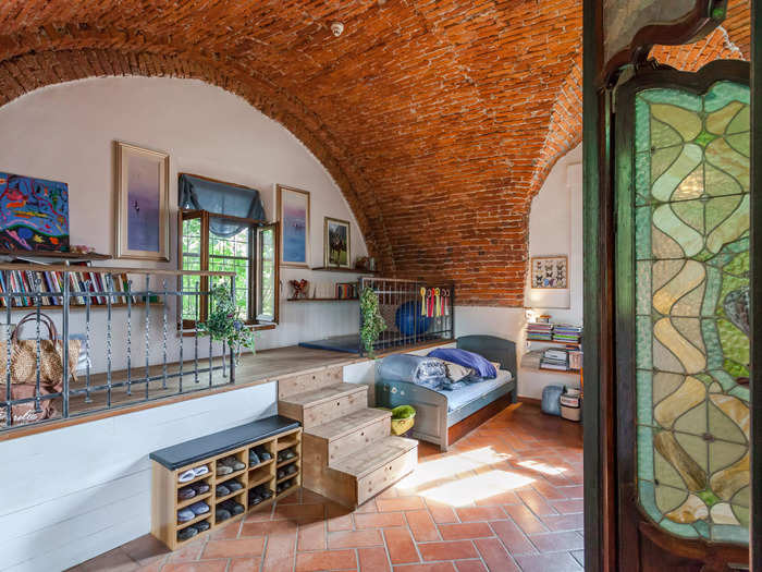 There are four bedrooms and three full bathrooms in the house. Pictured below is a bedroom with vaulted brick ceilings and stained glass windows.