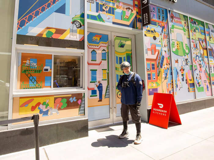 Doordash delivery workers, known as "Dashers," pick up their orders from a window in a separate space next to the food hall.