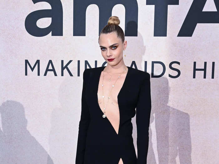 Cara Delevingne walked the red carpet in a simple black dress with a daring neckline.