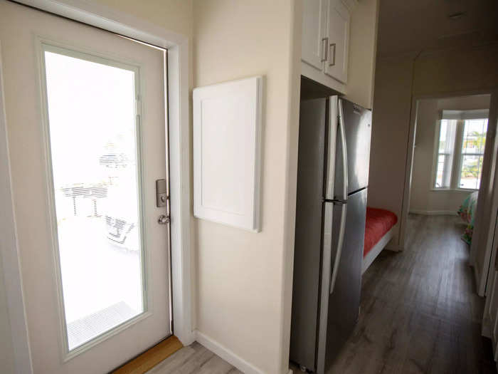 Back inside, the refrigerator is situated across from the kitchen towards the start of the hallway.