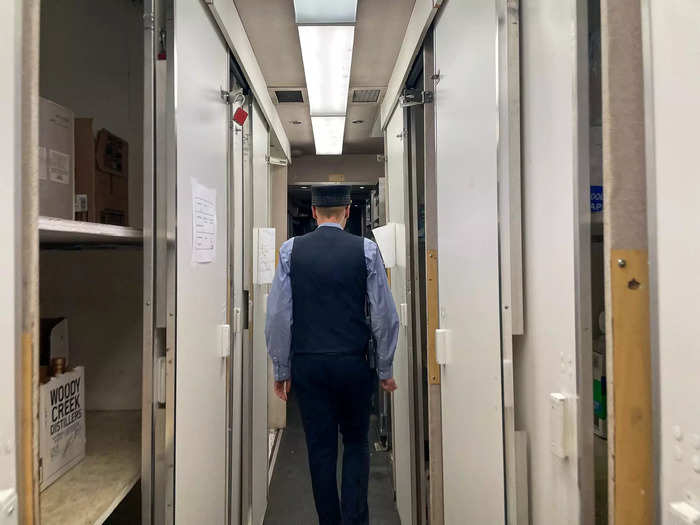 In this second crew area, cabinets line each wall, creating a tight passageway. They store everything needed to serve passengers, from jugs of orange juice to Colorado-distilled bourbon bottles.