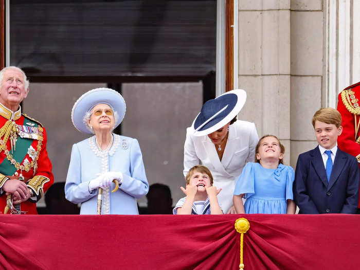 Kate Middleton appeared to lean down to talk to Louis as he stuck his hands in his mouth and glared at the sky.