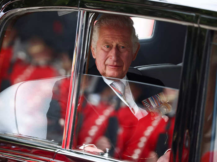 Prince Charles was the last family member to arrive, seen here looking out his car window as the cherry-red outfit of saluting royal guards reflects on the glass.