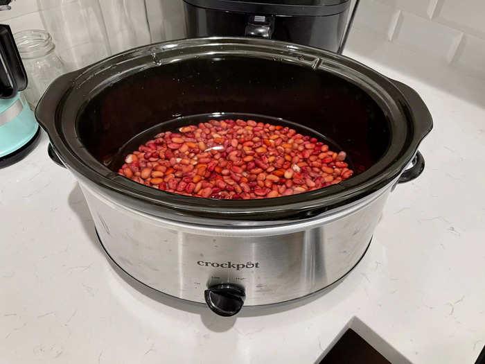 Add the red beans into the slow cooker with water.