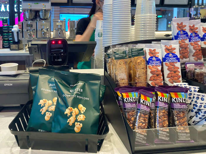 Just like other Starbucks locations, there are also food items, such as a selection of snacks like nuts, biscotti, and granola bars by the register ....