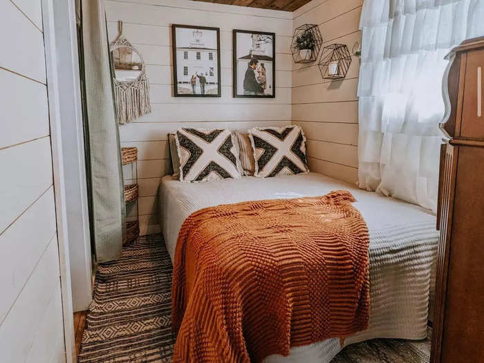 The completed tiny home has three rooms and is filled with rustic furniture.