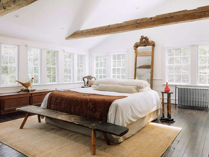 There are four bedrooms in the house, including a primary suite with a vaulted ceiling and hand-hewn wooden beams.