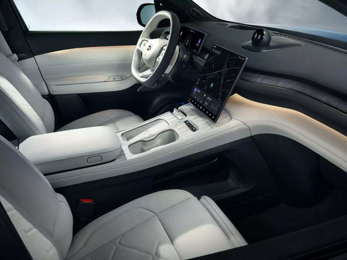 The interior is sleek and tech-packed, with a large infotainment touchscreen, a second display for the driver, and a cute, spherical voice assistant on the dashboard named Nomi.