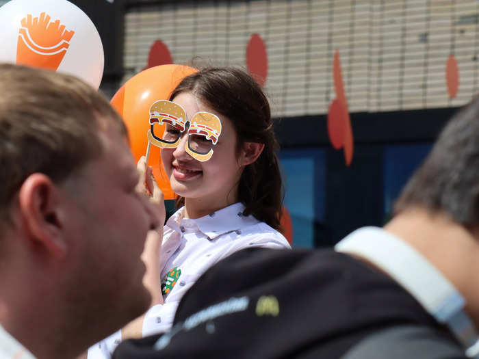 This employee held burger glasses to her face to entertain customers as they waited in line.