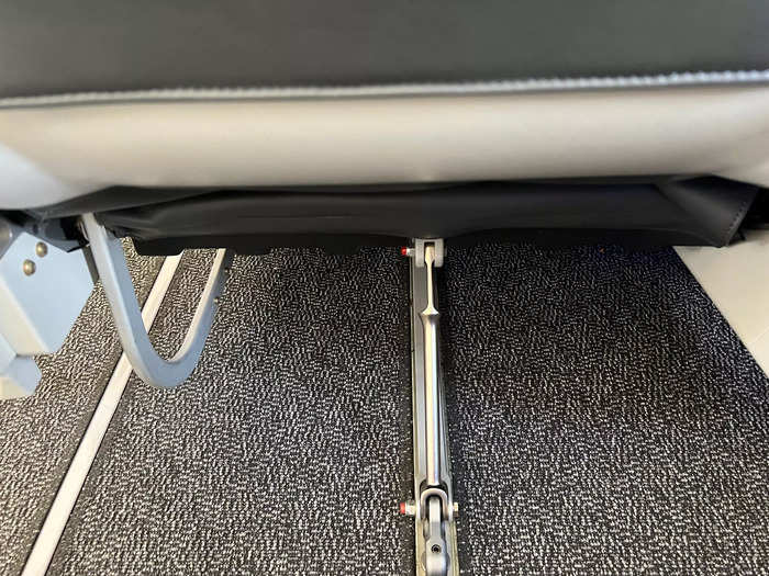 When settling into my seat, I noticed the aisle loungers have a metal piece that splits the under-seat space in half. I couldn