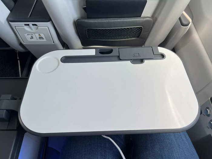 Each seat also features a large tray table that opens from the armrest in between the two loungers. Travelers can work or use the phone stand to stream media.