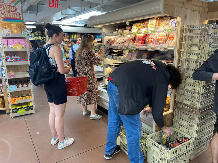 Each section was filled with customers holding baskets or wheeling shopping carts through the tight rows.