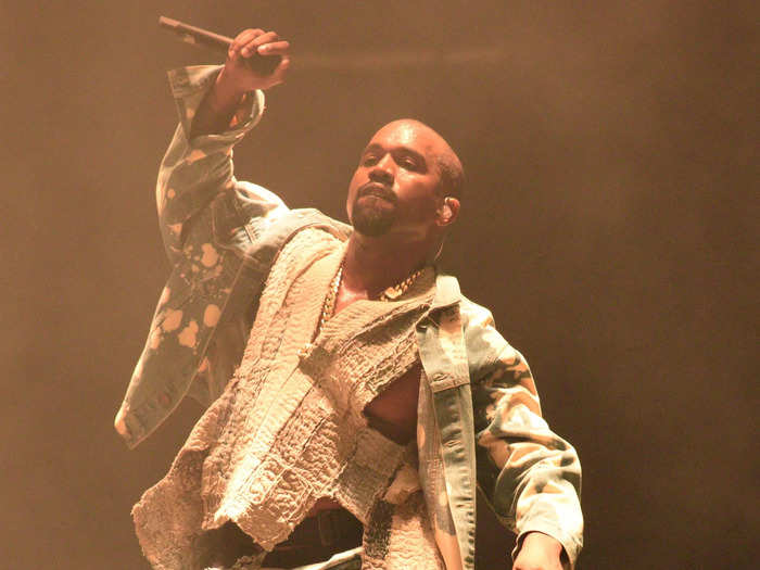 Kanye West opted for an acid-wash denim look with a distressed vest and a silver metallic mask for his 2015 headline performance.