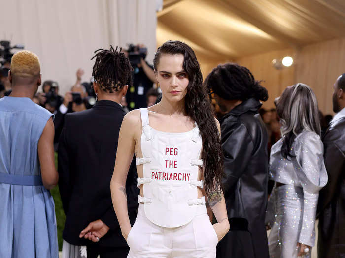 Cara Delevingne made a statement at the 2021 Met Gala in a white ensemble bearing the phrase "peg the patriarchy."
