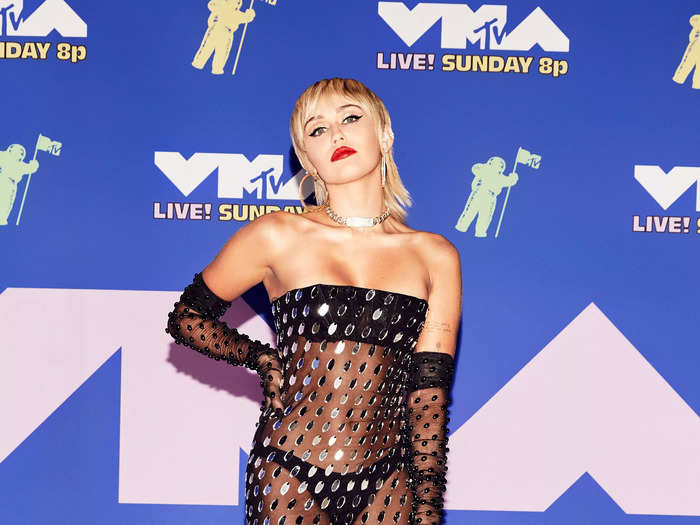 Miley Cyrus attended the 2020 MTV Video Music Awards looking like a disco ball in a sheer gown covered in shimmering mirrors.