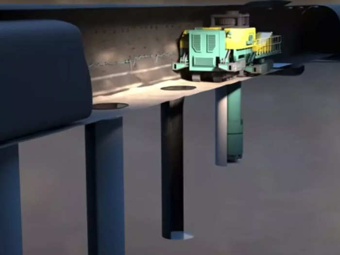 An automated digging machine goes along each tunnel to make a shaft for each canister, like in this animation.