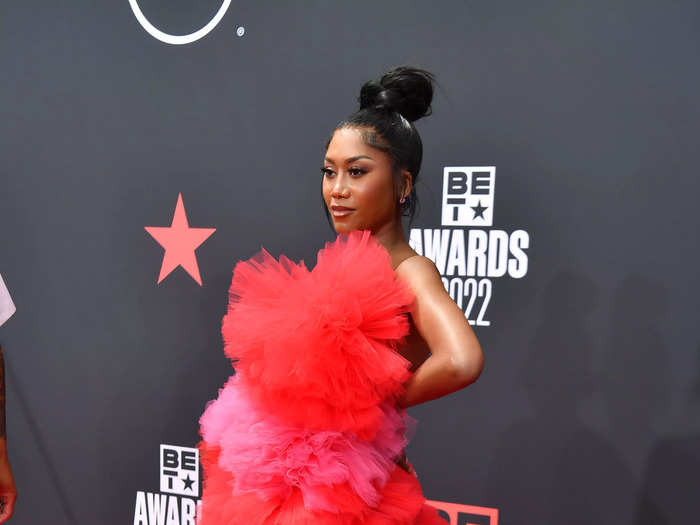 Muni Long stood out in a red-and-pink statement tulle gown with a striking silhouette.