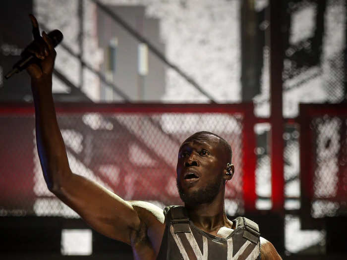 Stormzy headlined the 2019 festival wearing a stab-proof vest with a distressed Union Jack flag, as designed by the anonymous British artist Banksy.