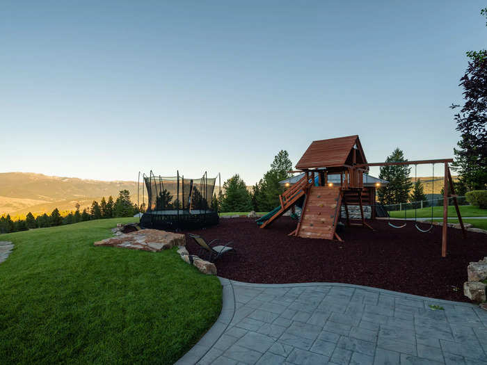 The outdoor playground has a trampoline, a double swing, and panoramic views of the forested hills that surround the compound.