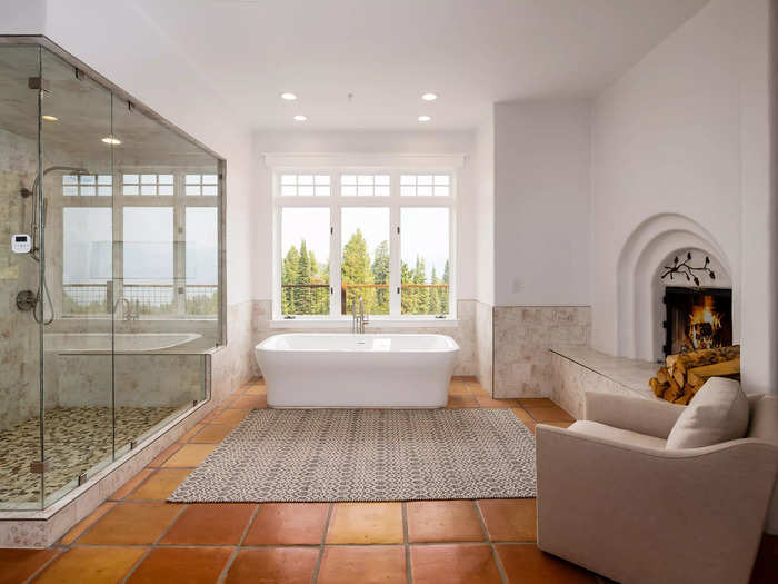 The master bathroom has a freestanding bathtub, a shower area, and a fireplace.