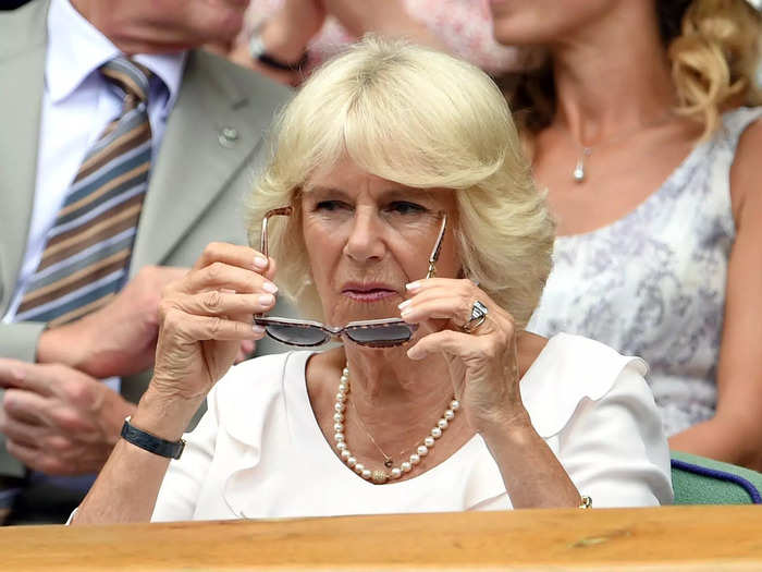 Attending without Charles, Camilla, Duchess of Cornwall, is pictured in the middle of popping her sunglasses on for a sunny day at Wimbledon in 2015.