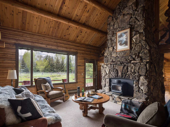 A massive stone fireplace dominates the cabin