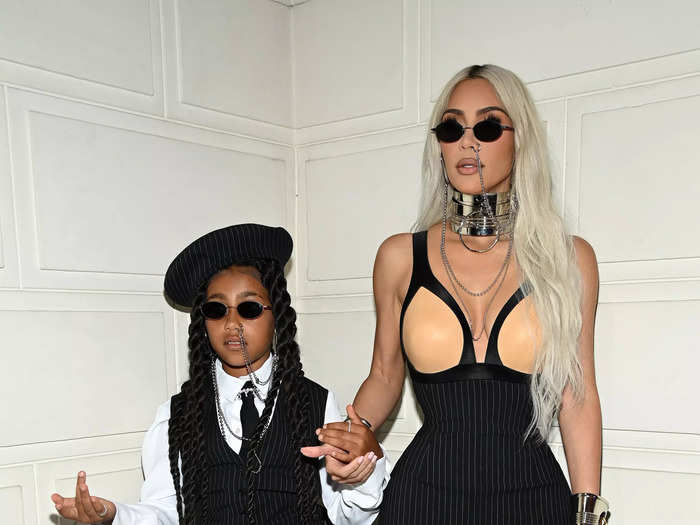 Kim Kardashian and North West arrived at the Jean Paul Gaultier fashion show in coordinated pinstripe looks and matching nose-ring chains.