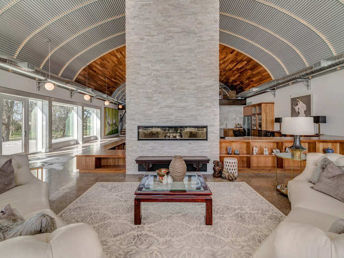 A floor-to-ceiling electric fireplace and chimney form the centerpiece of the lounge area.