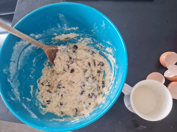 After mixing the raisins, sugar, and salt to the mixture, add the eggs and some of the milk.